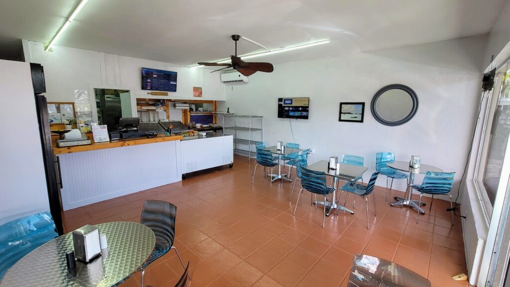 Ty's Deli in Vero Beach Florida off 20th street inside dining room.  White walls with diamond plate design tables, clear blue chairs with metal legs