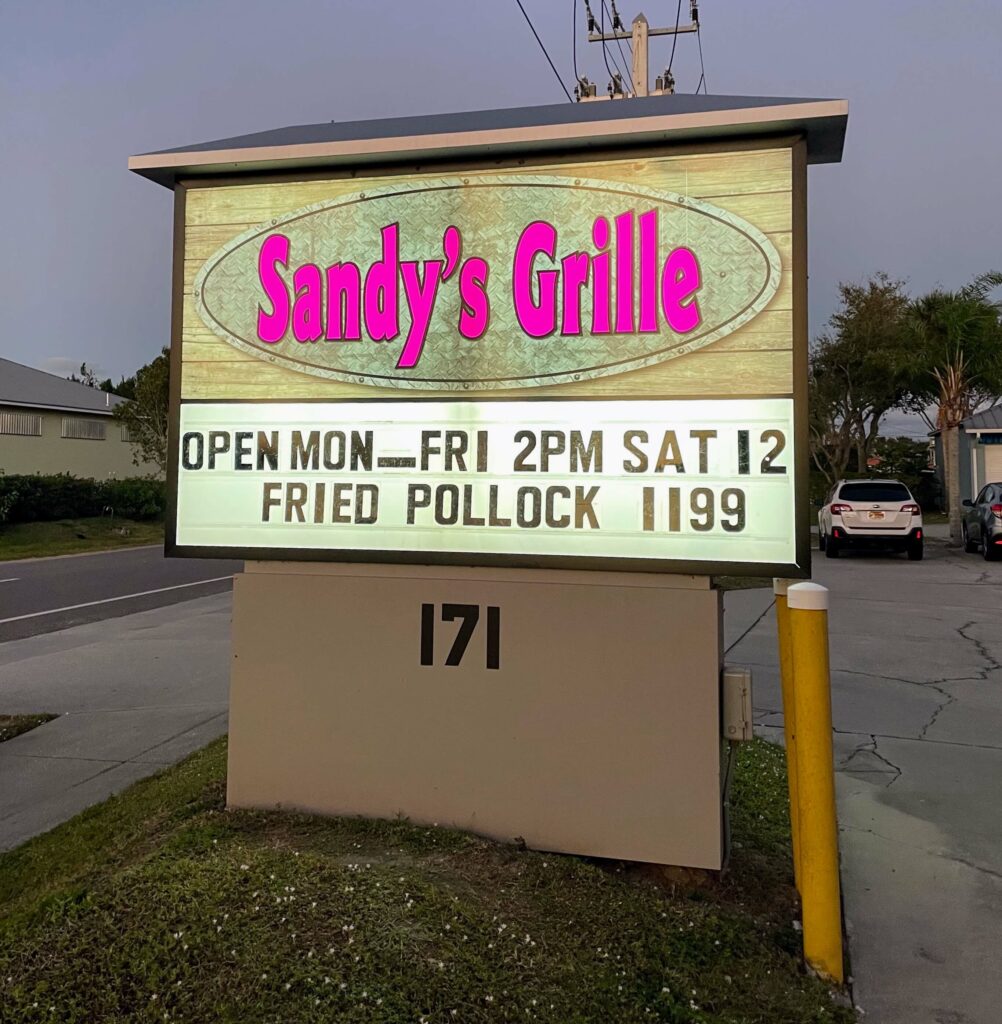 Sandy's Grille sign in Sebastian, Florida, welcoming customers to enjoy delicious food and drinks at this local eatery.
