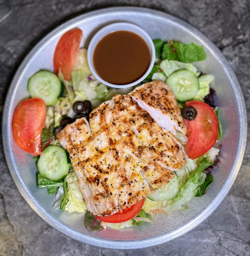 Grilled Mahi Salad at Sandy's Grille in Sebastian, Florida, a delicious and healthy dish made with fresh grilled Mahi, mixed greens, and topped with a tangy dressing.