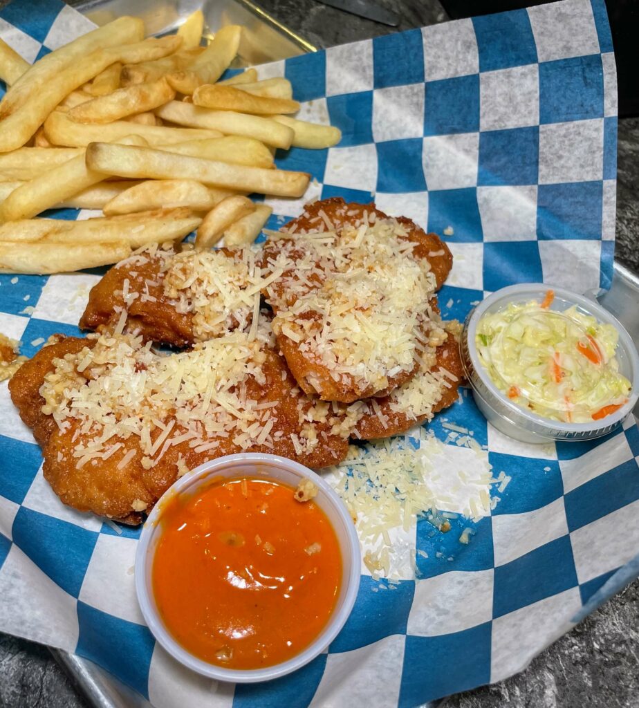 Garlic Parmesan Chicken Tenders at Sandy's Grille in Sebastian, Florida, a mouthwatering appetizer or entree made with tender chicken breast strips coated in a flavorful garlic parmesan breading