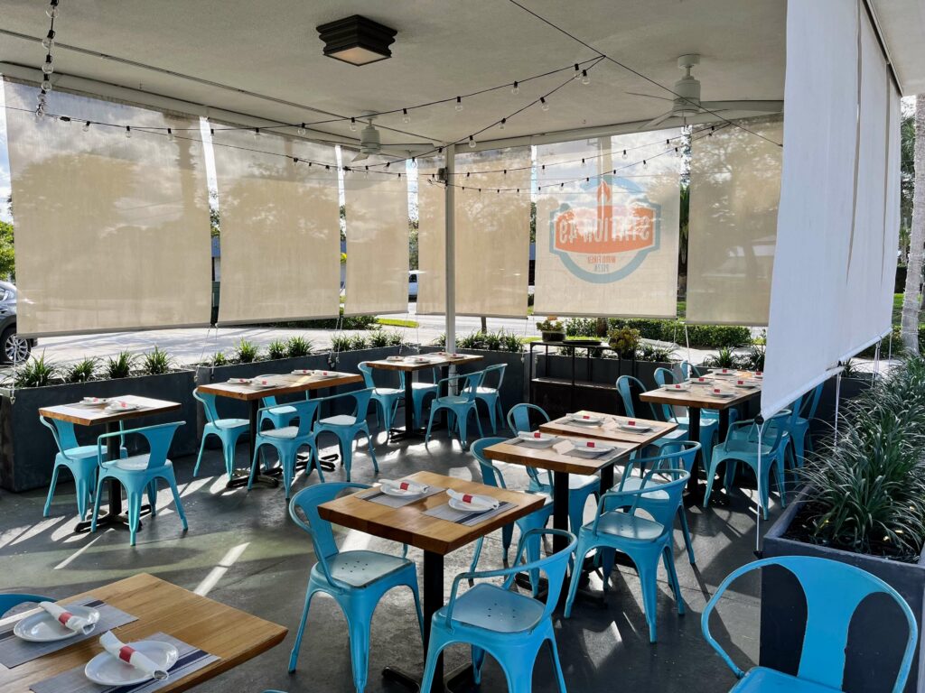 The outdoor patio at Station 49 pizza restaurant, a serene and peaceful space surrounded by greenery. Guests can enjoy their pizza and drink under the warm sun or stars while surrounded by nature
