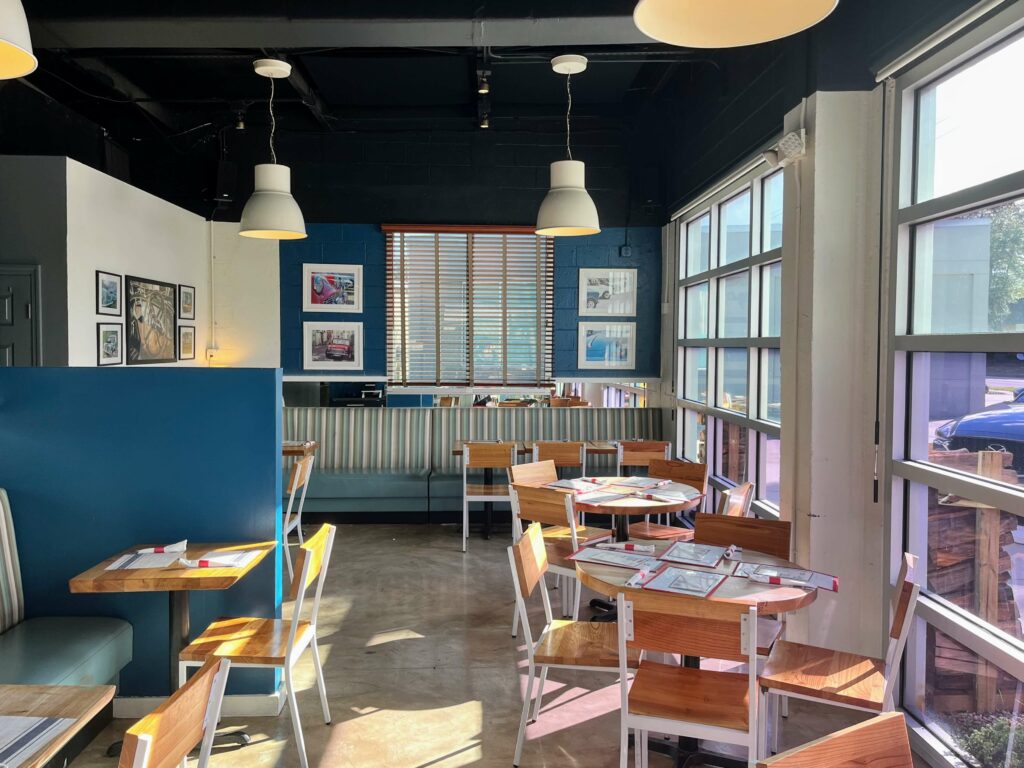 The inside dining room of Station 49 pizza restaurant, a comfortable and welcoming space with dim lighting, wooden furniture, and rustic decor. Guests can enjoy their delicious wood-fired pizzas in a cozy and inviting atmosphere