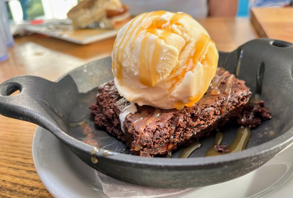 A warm chocolate brownie served with a scoop of Vanilla Bean gelato on top, a perfect dessert to share with friends or loved ones after a meal, rich, chocolatey and melts in your mouth