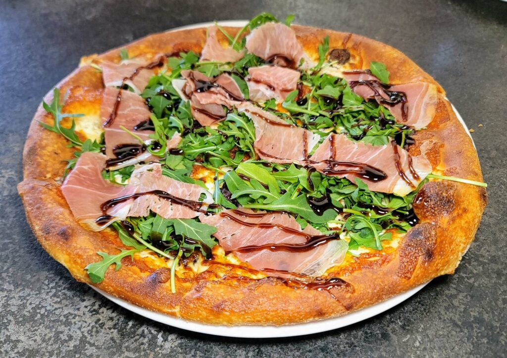 CAPRI PIZZA - This pie boasts mission fig, goat cheese, mozzarella, prosciutto, arugula, and a balsamic agro dolce at City Cellar Wine Bar & Grill in the Square in West Palm Beach Florida