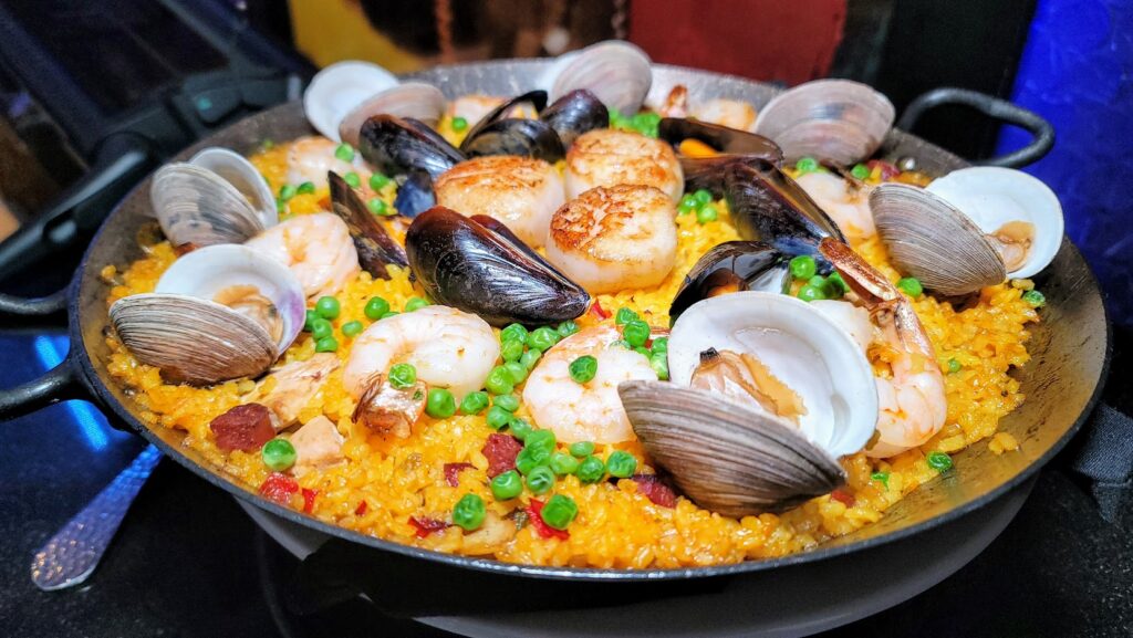 Paella A La Costa – This Calasparra Rice Dish is made with Clams, Mussels, Scallops, Shrimp, Chorizo, Chicken, peppers, peas from The Wave Kitchen & Bar located inside Costa d'Este Resort in Vero Beach, Florida.