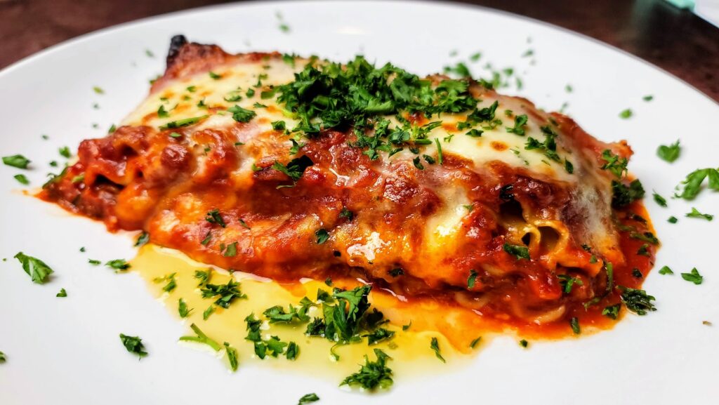 Veal Osso Bucco Lasagna – 12-hour braised veal Osso Bucco, fresh pasta sheets, ricotta cheese, fresh herbs, and tomato ragu served at Scampi Grill in Vero Beach, Florida.