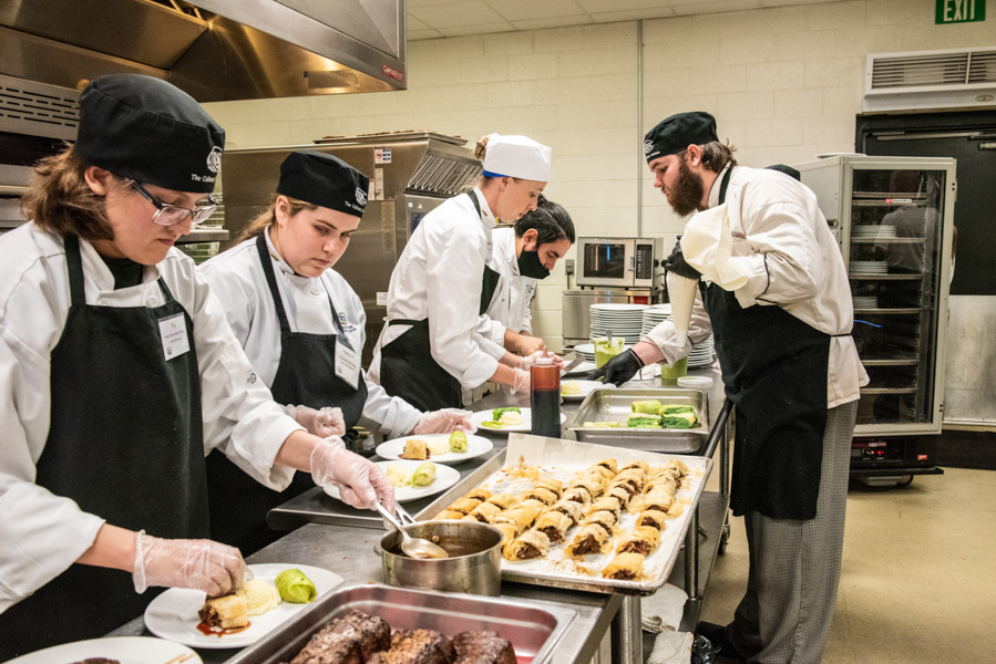 Indian River State College culinary students work alongside a chef to plate his masterchef dish for a local chef competition that took place on the Mueller campus in vero beach florida