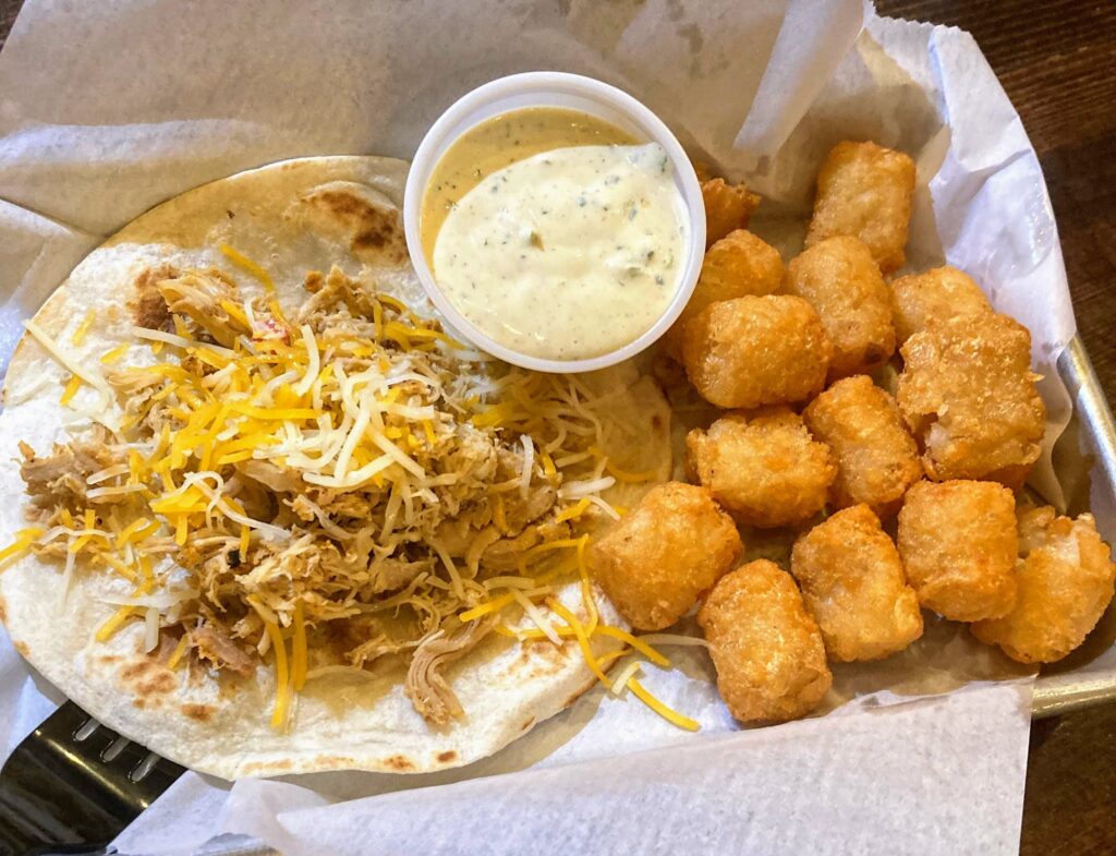 single kids chicken taco with a side of tater tots from Taco Dive Downtown Fort Pierce location on the treasure coast of florida
