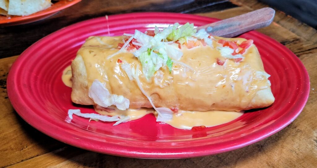 chimichanga covered with cheese sauce as prepared by blue agave in vero beach florida