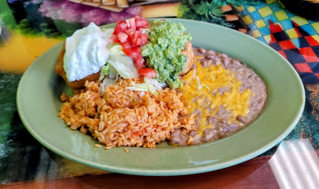 chimichanga, sour cream, dice tomatoes, guacamole, rice & beans as prepared by el tapatio mexican grill located in vero beach florida 
