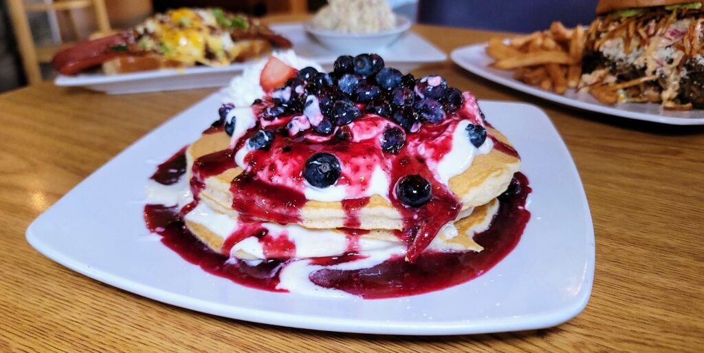 a plate of blueberry pancakes from Berry Fresh Cafe located in Stuart Florida