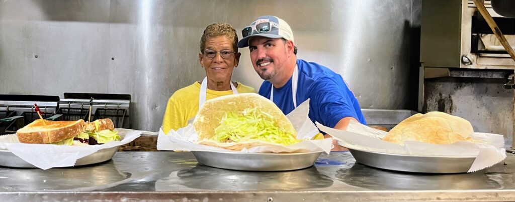 A photo of the owner, Miss Betty and Chef Tyler in the kitchen at Mrs Mac's Fillin Station restaurant located in Vero Beach Florida