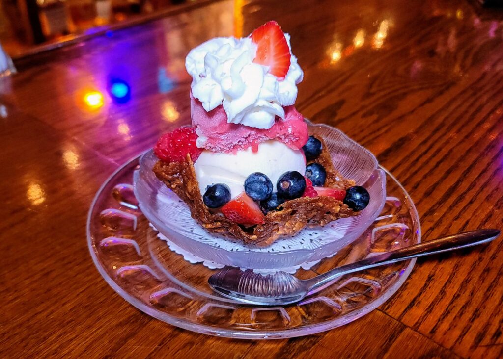 Almond Praline basket dessert with vanilla Häagen-Dazs ice cream, raspberry sorbet, whipped cream, and fresh berries as prepared by the Ocean Grill in Vero Beach Florida