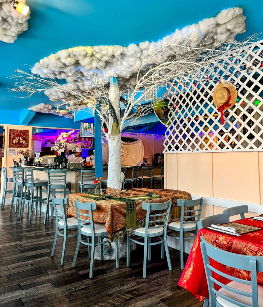 Inside dining room featuring a tree with fluffy clouds on the ceiling at Thai Smile & Sushi located in Sebastian florida