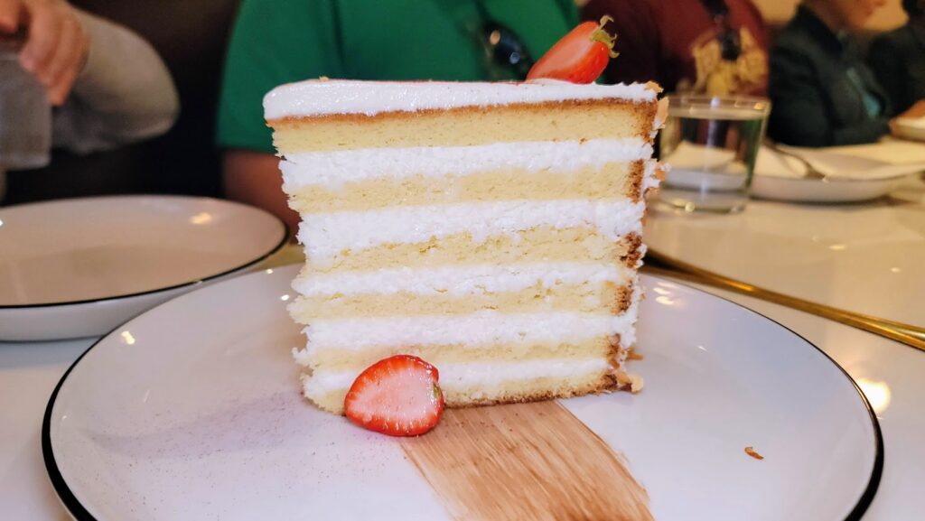 A slice of the Tom Cruise and Oprah Winfrey's famous coconut cake as served at Benne's by Peninsula Grill on the Charleston Culinary Tour in Charleston South Carolina