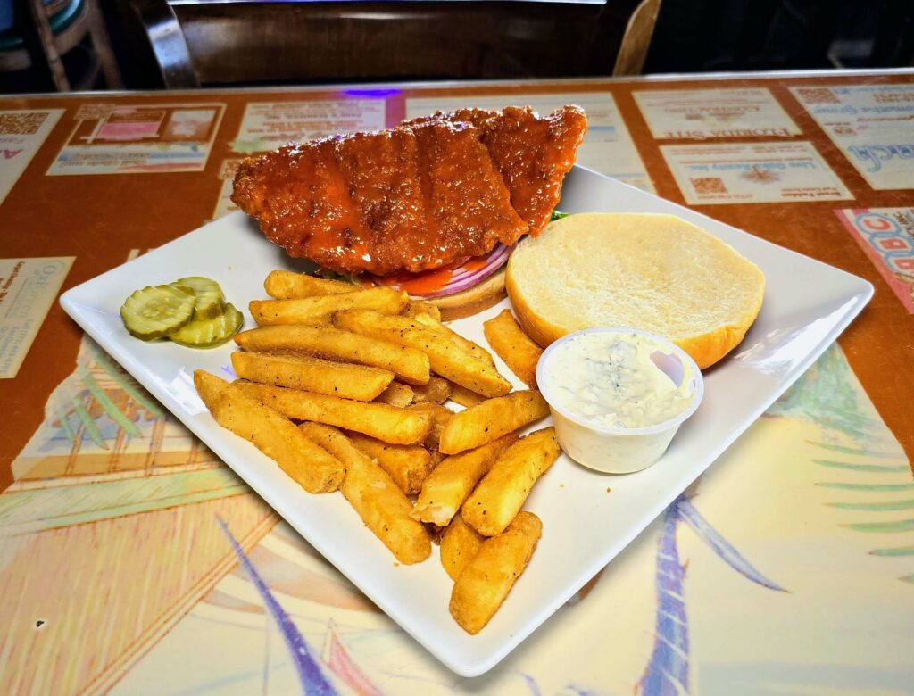 Buffalo chicken sandwich with french fries as prepared by Riverside Cafe in Vero Beach Florida