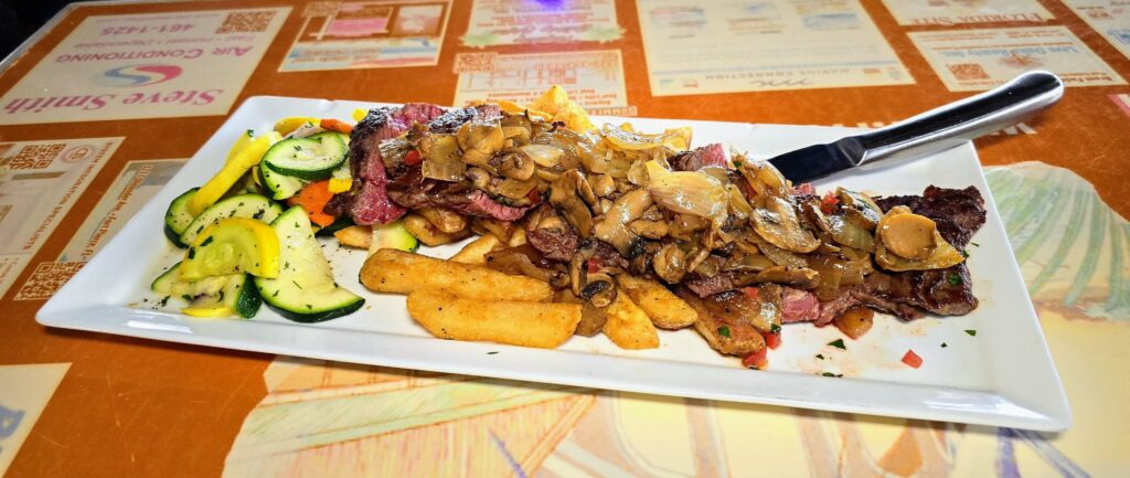 Grilled skirt steak served over french fries as prepared by Riverside Cafe in Vero Beach Florida