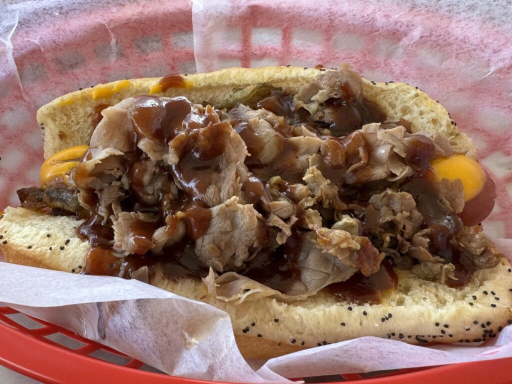 Nebraska Dog: Cheddar, grilled onions, bacon, Italian beef and BBQ as prepared by Mustard's Last Stand in Melbourne, Florida