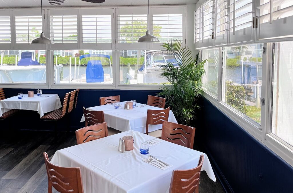 Inside patio dining with a view of the river and marina at Cooper's Chop House & Seafood located in Royal Palm Pointe in Vero Beach Florida