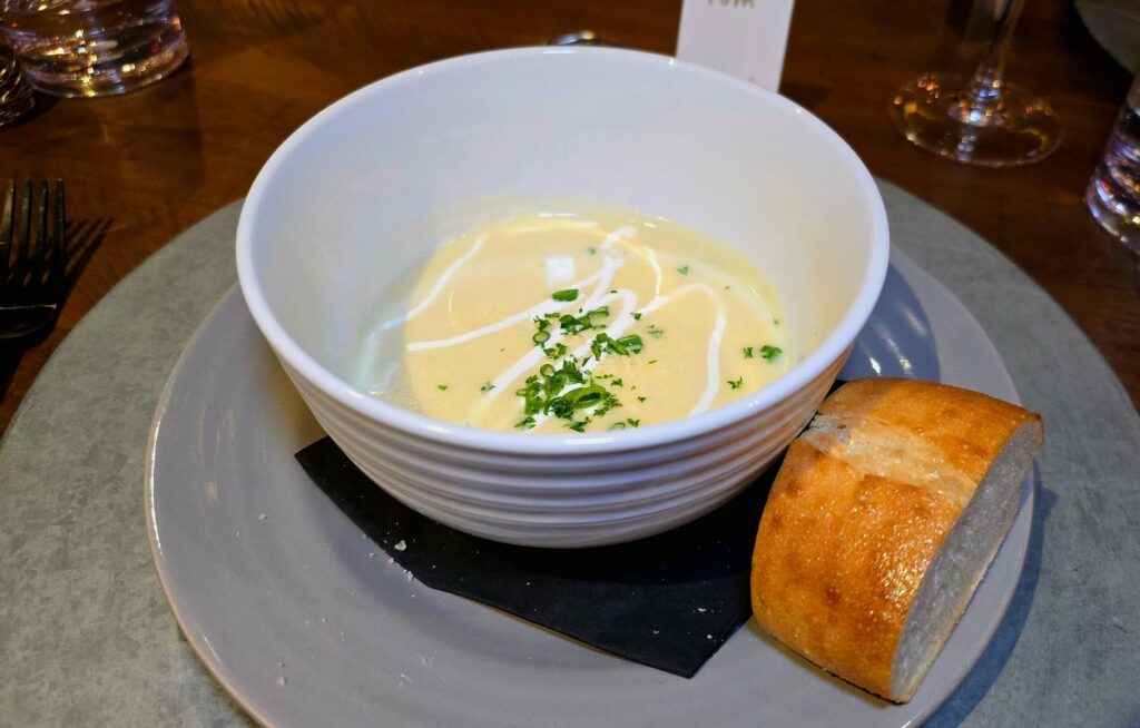 Course Two - Potato purée soup with a slice of bread as served at the supper club held at the Sun Market Sauce Co. in Vero Beach Florida